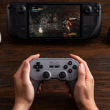 8BitDo Pro 3 Bluetooth – Gray-controller med dock – Controller i hænder ved separat spilleenhed som eksempel
