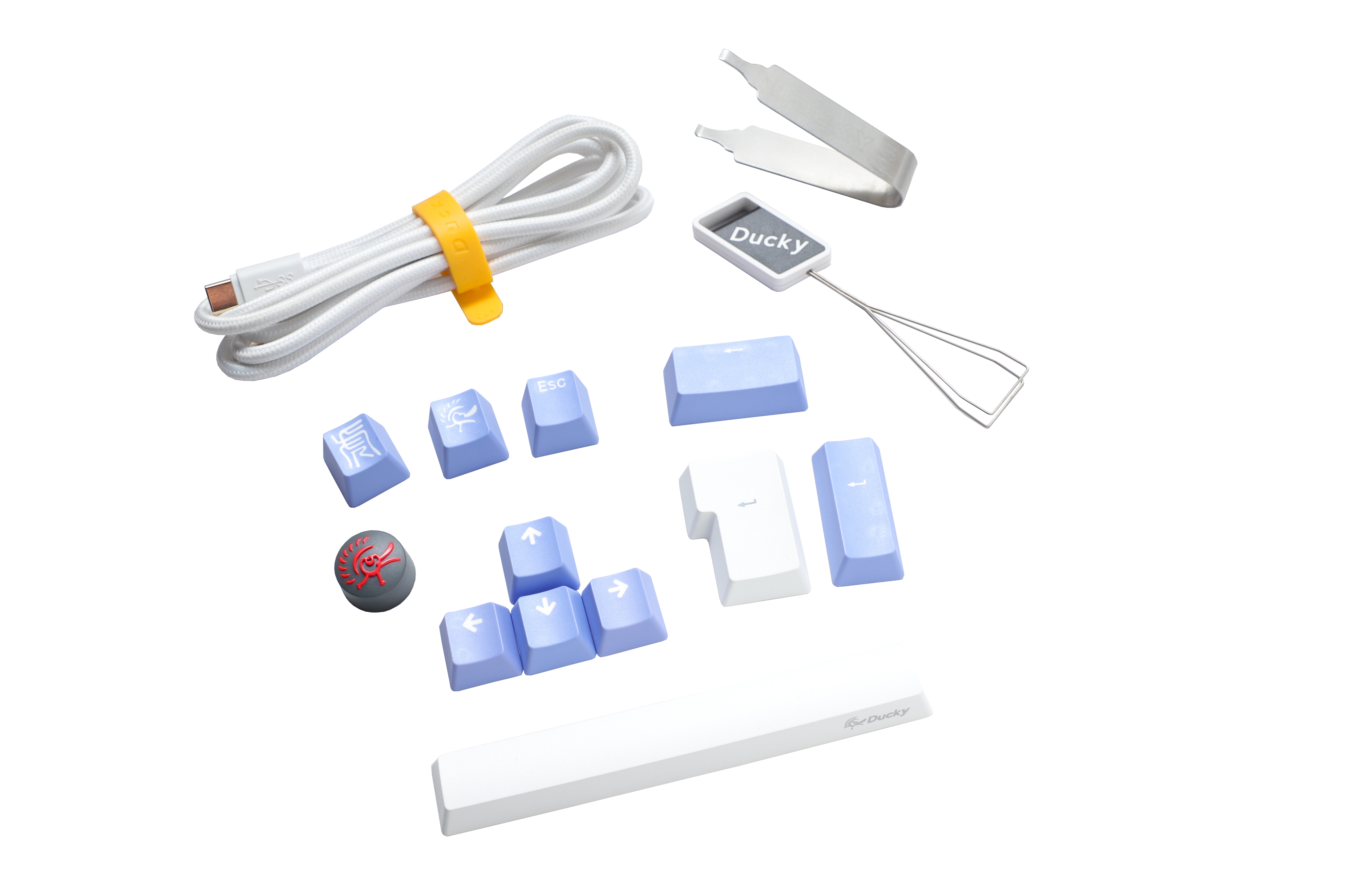 Various Ducky keyboard accessories including a USB cable, keycap puller, and replacement PBT keycaps in blue and white, displayed on a clean, white background.