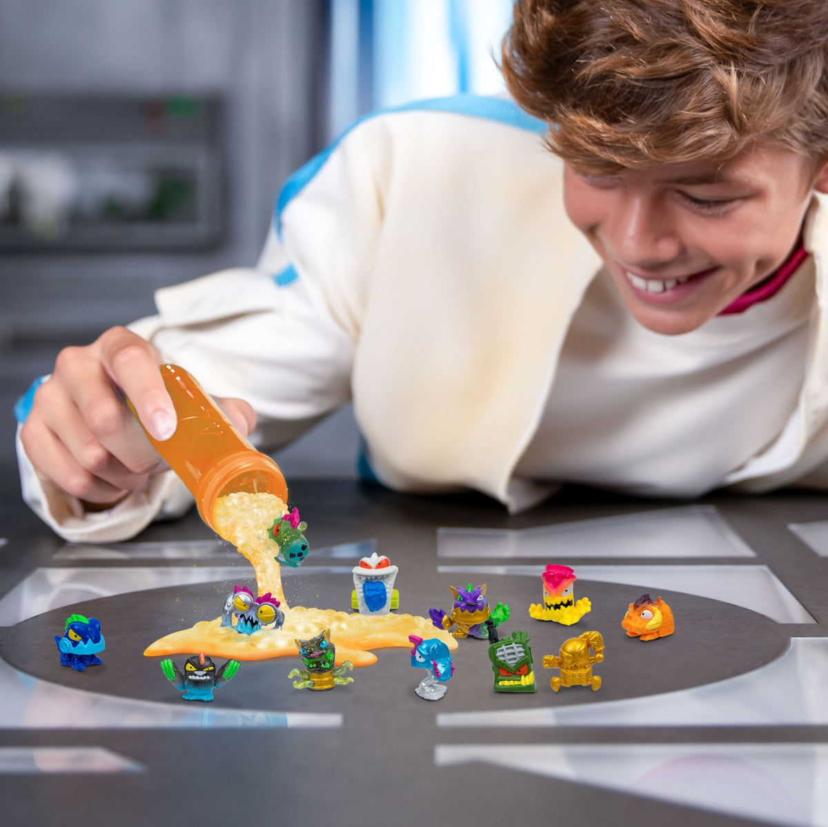 Dreng hælder orange indhold ud ved MrBeast Lab Swarms-figurer