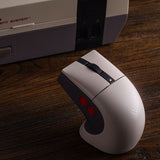 8BitDo Retro R8 N Edition – gamingmus med ladestation – Mus og ekstra rekvisitter på bord som eksempel
