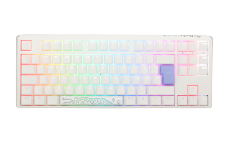 A Ducky white mechanical keyboard with PBT keycaps and pastel-colored, backlit keys featuring RGB lighting. The space bar has an artistic, teal wave design.