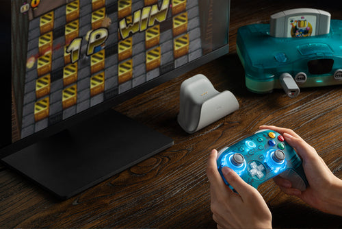 8BitDo Ultimate 2 Wireless 2.4G – Controller – Clear Blue – controller i brug ved skærm; producentillustration